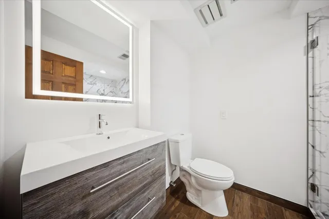 a bathroom with a toilet a sink and mirror