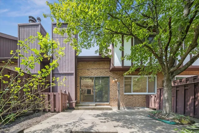 a front view of a house with a tree
