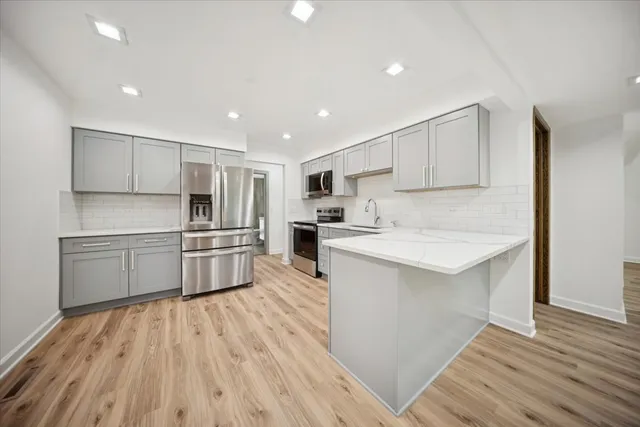 a kitchen with white cabinets and stainless steel appliances