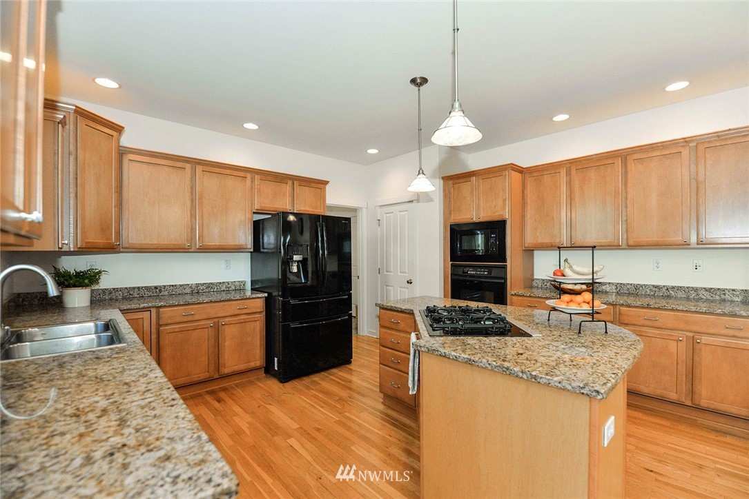 21814 41st Avenue Southeast Bothell, WA 98021 - Photo 14 of 30 a kitchen with stainless steel appliances granite countertop a refrigerator stove sink and cabinets