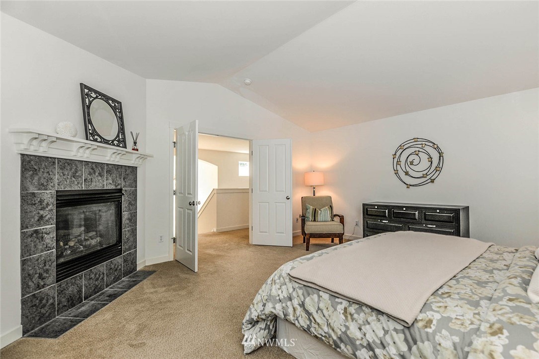 21814 41st Avenue Southeast Bothell, WA 98021 - Photo 21 of 30 a bedroom with a bed and a fireplace