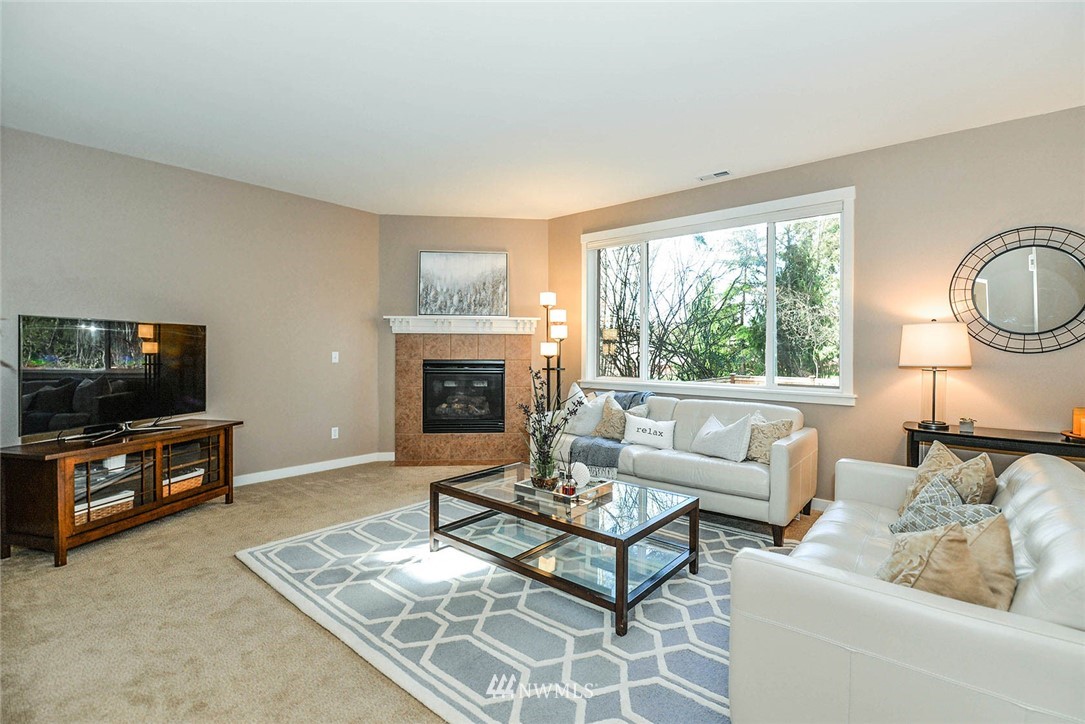 21814 41st Avenue Southeast Bothell, WA 98021 - Photo 10 of 30 a living room with furniture a flat screen tv and a fireplace