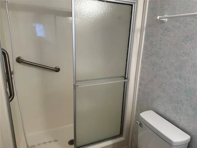a bathroom with a toilet and a shower
