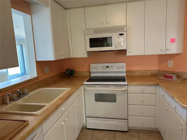 a kitchen with white cabinets sink and white appliances