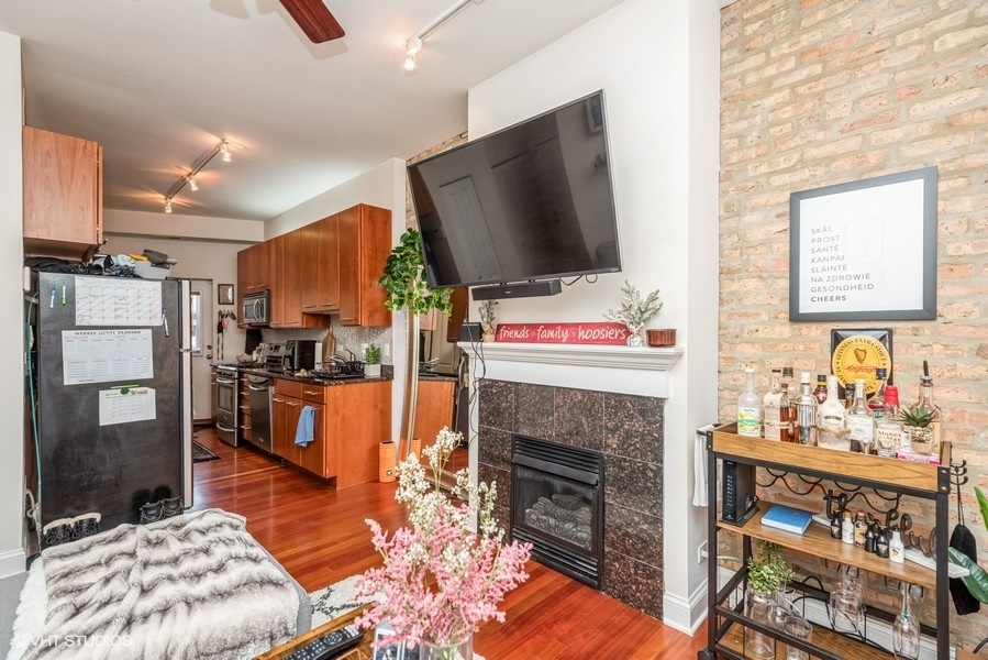 Undisclosed Address Chicago, IL 60614 - Photo 4 of 9 a living room with furniture a flat screen tv and a fireplace