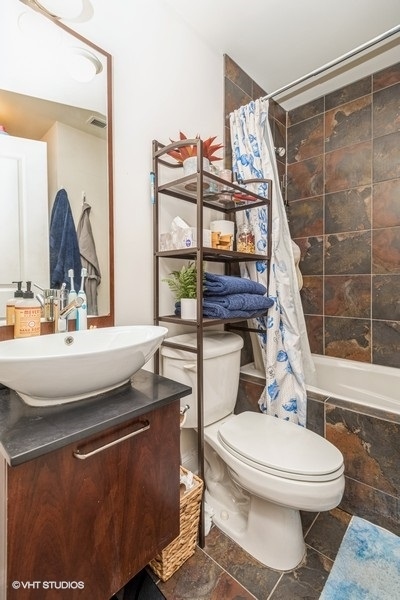 Undisclosed Address Chicago, IL 60614 - Photo 8 of 9 a bathroom with a sink toilet and shower