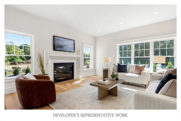 a living room with furniture a fireplace and a large window