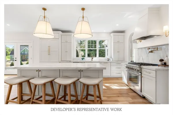 a kitchen with stainless steel appliances granite countertop a sink a stove and a wooden floors