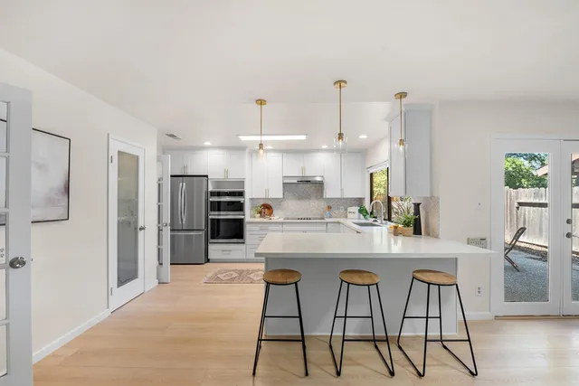 a kitchen with stainless steel appliances kitchen island granite countertop a refrigerator and microwave