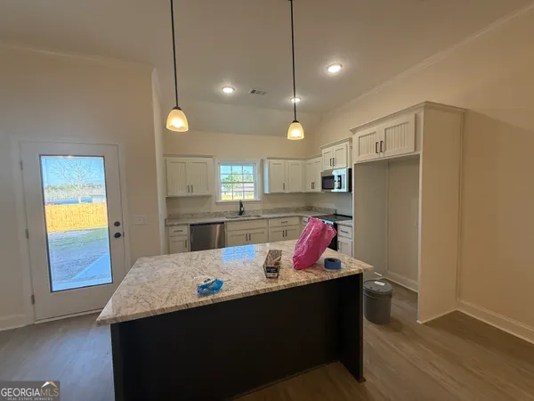a kitchen with a refrigerator sink and wooden floor