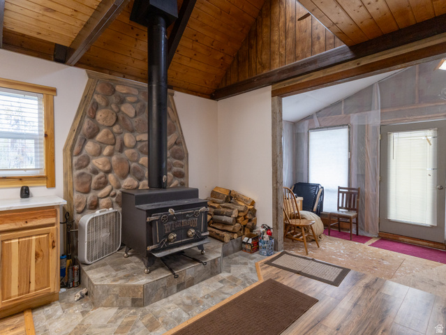 5082 Pine Crest Road Evanston, UT 82930 - Photo 12 of 25 Interior stone-clad fireplace with a wood-burning stove and a slate-look tile hearth