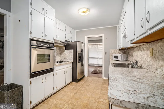 a kitchen with granite countertop a refrigerator stove and sink