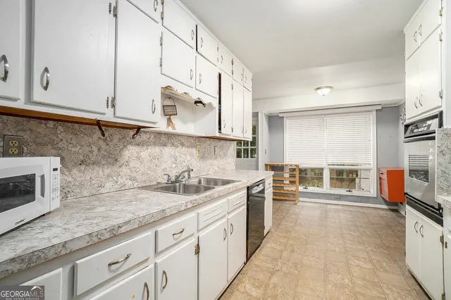 a kitchen with stainless steel appliances granite countertop a sink stove and microwave