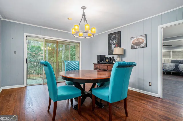 a view of a dining room with furniture a chandelier and wooden floor