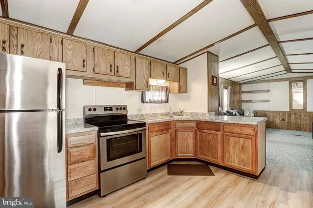 a kitchen with stainless steel appliances granite countertop a refrigerator a stove a sink and a microwave