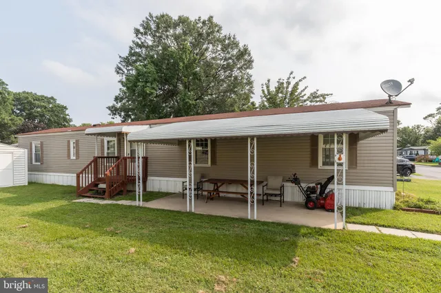a view of a house with a yard and sitting area