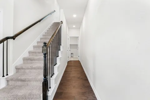 a view of a hallway with wooden floor