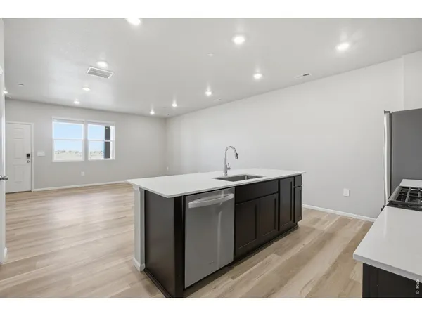 a kitchen with a sink and wooden floor