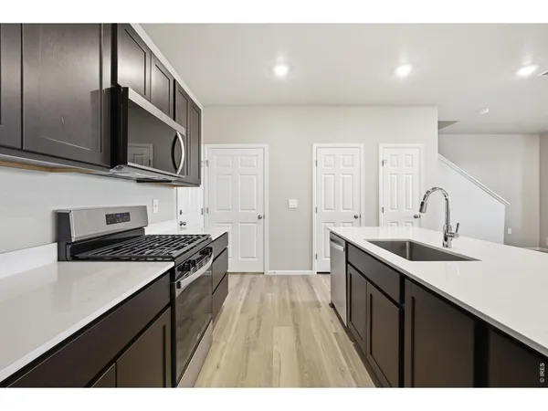 a kitchen with a sink stove top oven and refrigerator