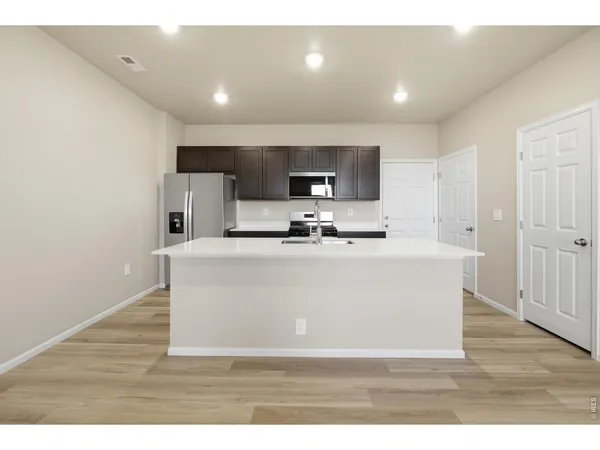 a view of living room with stainless steel appliances wooden floor and view living room