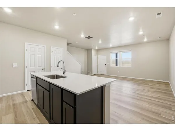 a kitchen with a sink and wooden floor