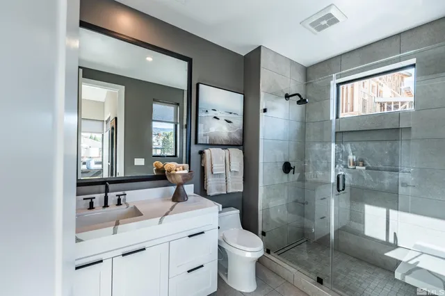 a bathroom with a granite countertop sink toilet and shower