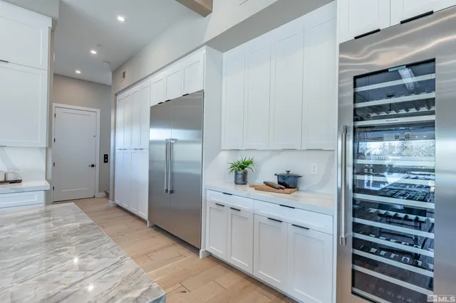 a kitchen with a refrigerator and white cabinets