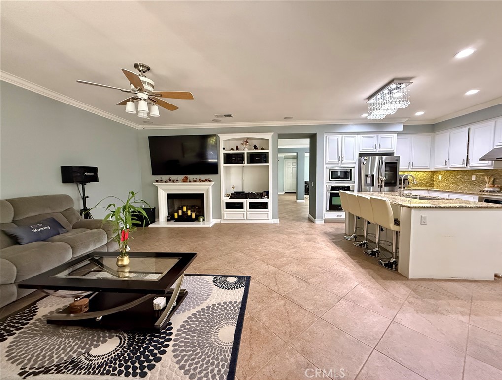 33467 Pitman Lane Menifee, CA 92584 - Photo 12 of 40 a living room with furniture a flat screen tv and a fireplace