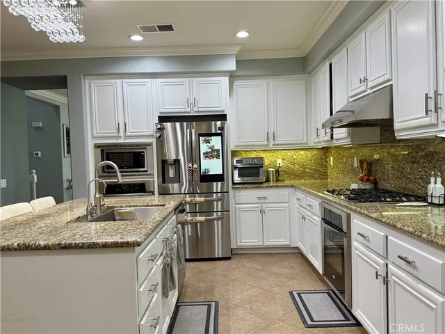a kitchen with granite countertop stainless steel appliances and white cabinets