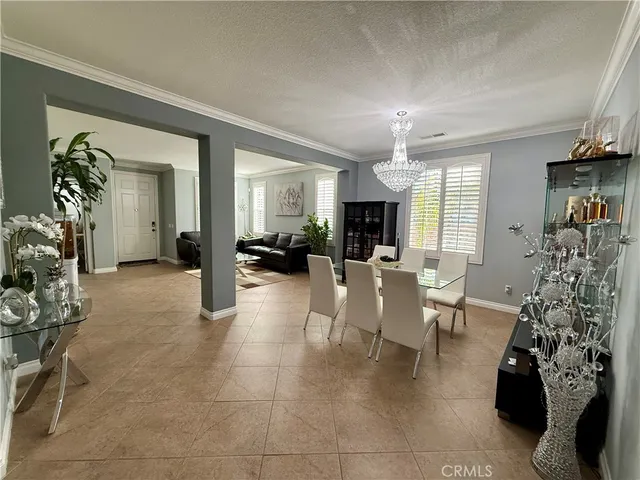 a living room with furniture a chandelier and a dining table