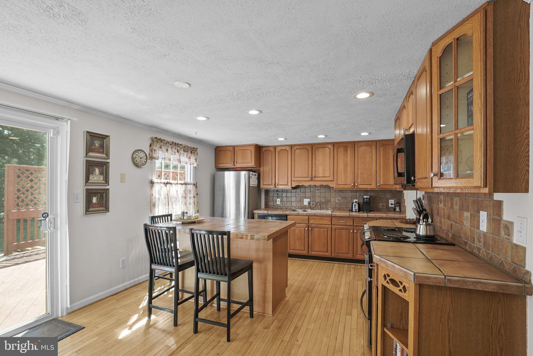 7129 Banjo Court Columbia, MD 21045 - Photo 3 of 46 a kitchen with a table chairs refrigerator and cabinets