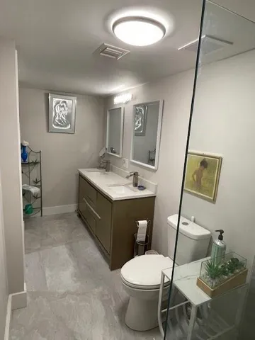a bathroom with a sink vanity mirror and toilet