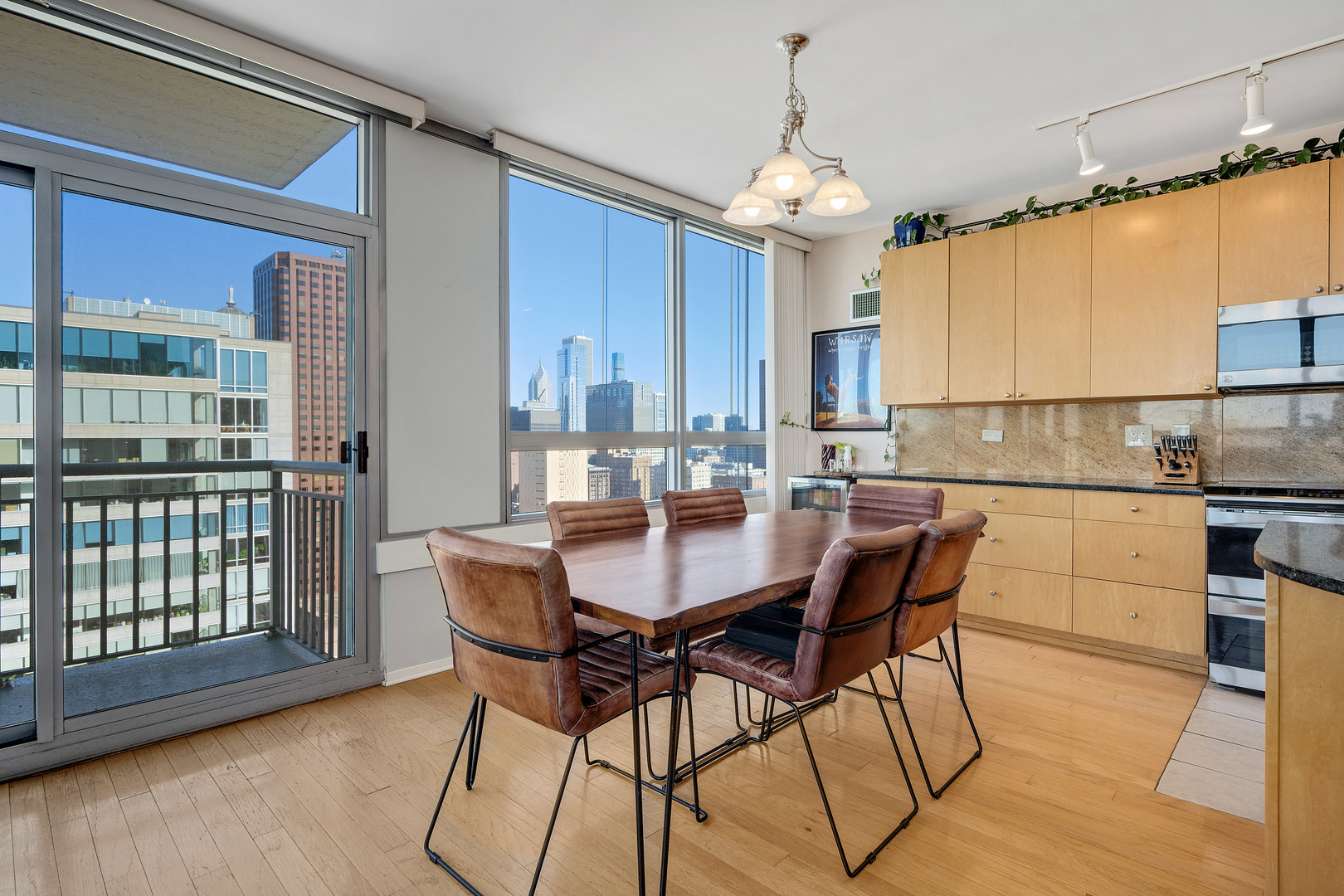 701 South Wells Street, Unit 3006 Chicago, IL 60607 - Photo 14 of 32 a kitchen with stainless steel appliances kitchen island granite countertop a table chairs and a refrigerator
