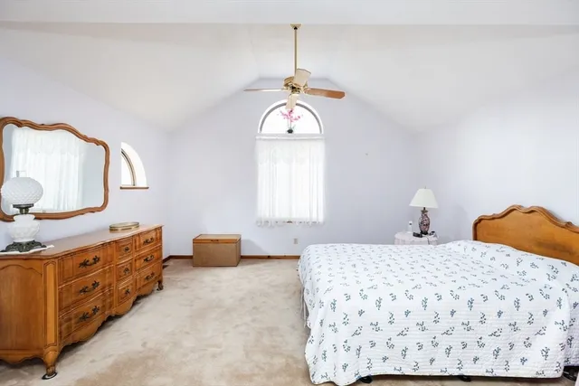 a bedroom with a bed and dresser with mirror