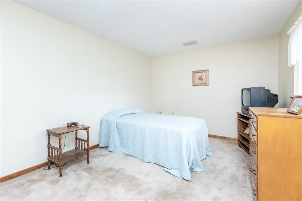 81 Clement Court, Unit 81 Haverhill, MA 01832 - Photo 20 of 36 a bedroom with a bed and a chair