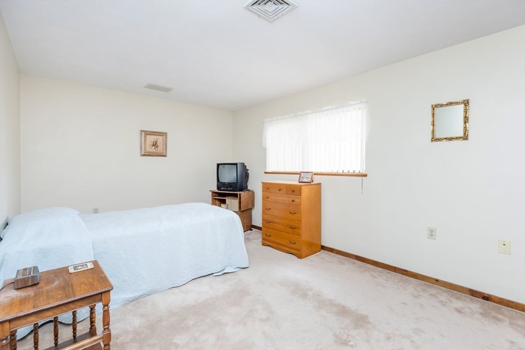 81 Clement Court, Unit 81 Haverhill, MA 01832 - Photo 21 of 36 a bed room with a bed and a chair