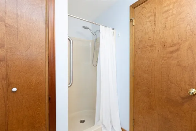 a bathroom with a shower and a glass door