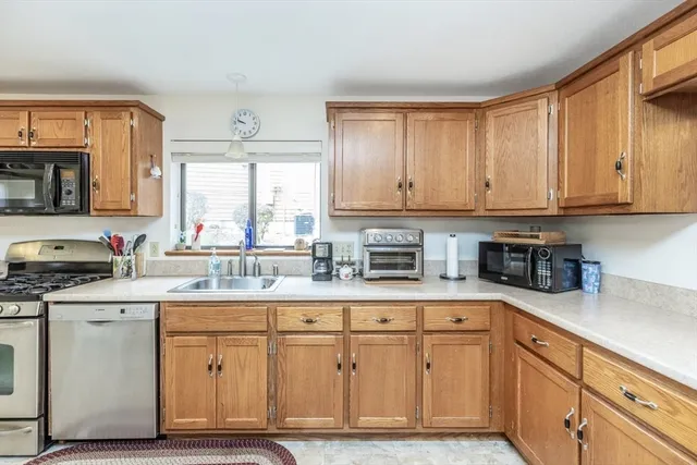 a kitchen with granite countertop cabinets stainless steel appliances a sink and window