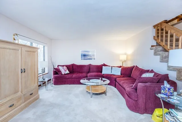 a living room with furniture a rug and a window