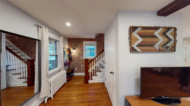 a view of hallway with stairs and wooden floor
