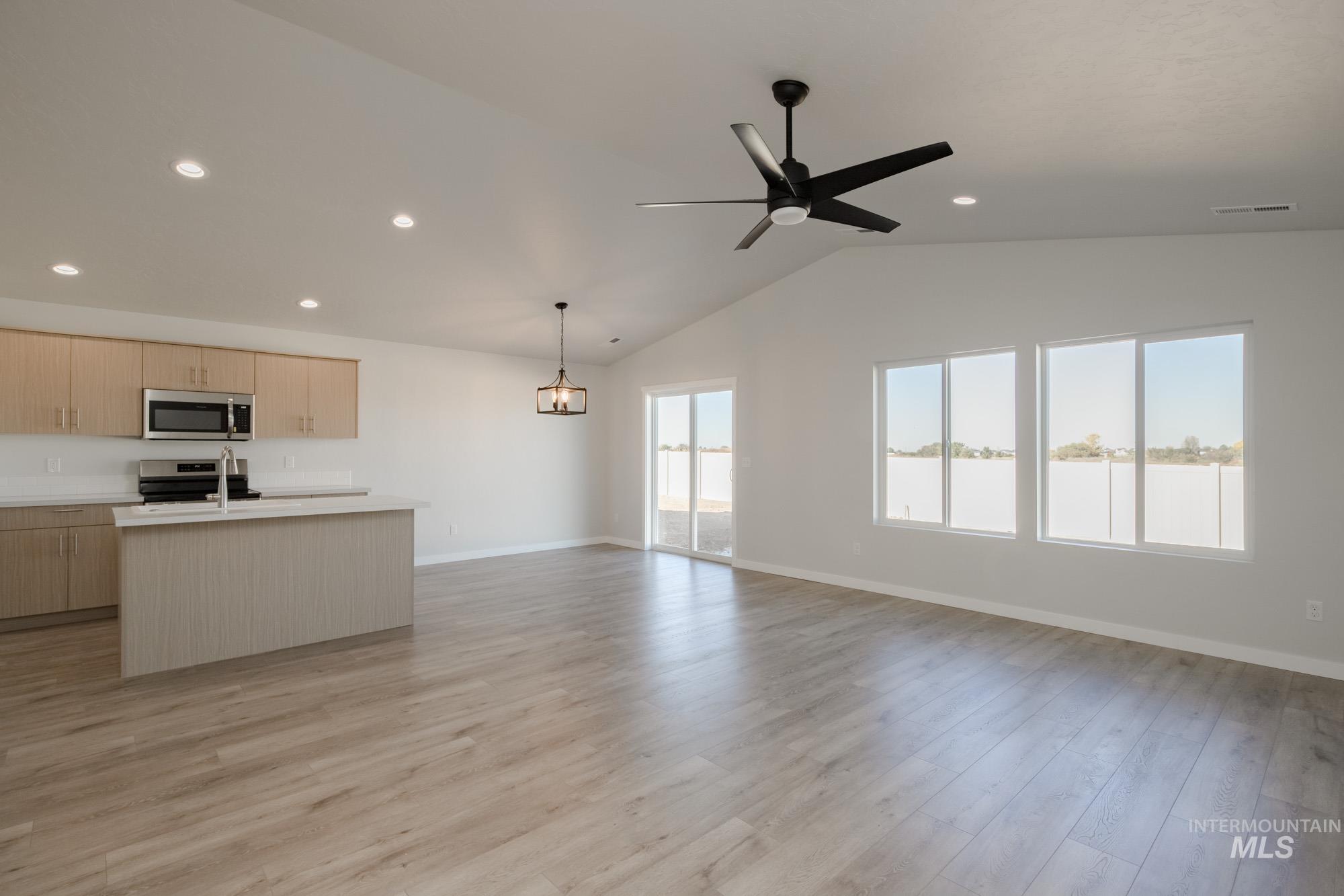 1832 West Unforgettable Street Meridian, ID 83642 - Photo 22 of 22 Kitchen with a center island with sink, open floor plan, light countertops, light brown cabinetry, and vaulted ceiling