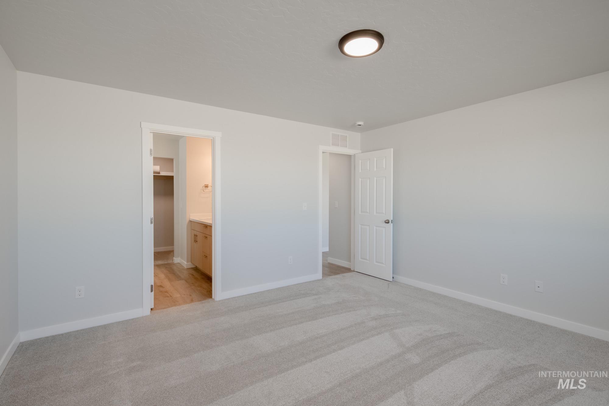 1832 West Unforgettable Street Meridian, ID 83642 - Photo 18 of 22 Unfurnished bedroom with light carpet, ensuite bath, and a walk in closet