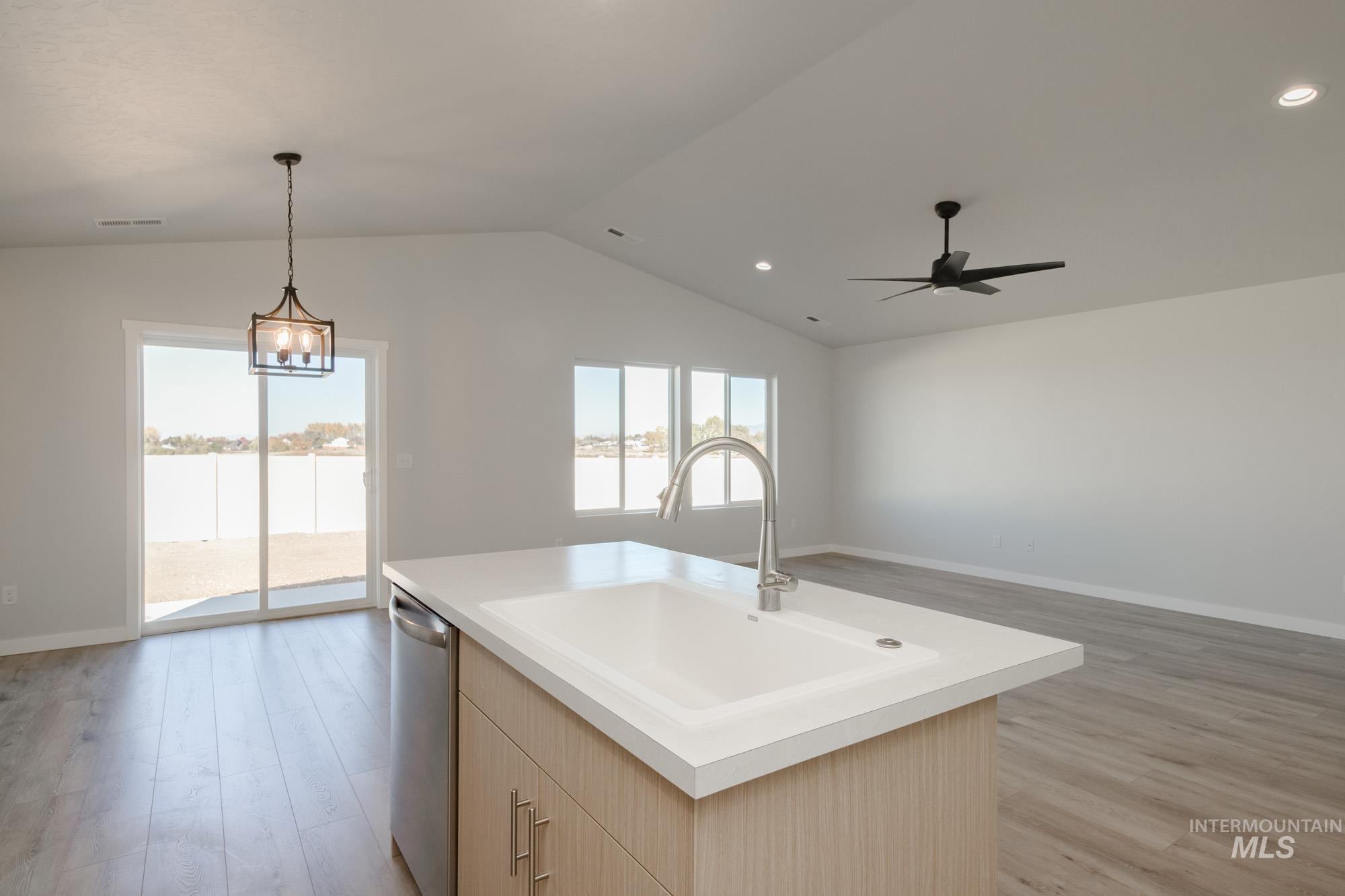 1832 West Unforgettable Street Meridian, ID 83642 - Photo 21 of 22 Kitchen featuring light brown cabinetry, open floor plan, light wood finished floors, light countertops, and stainless steel dishwasher