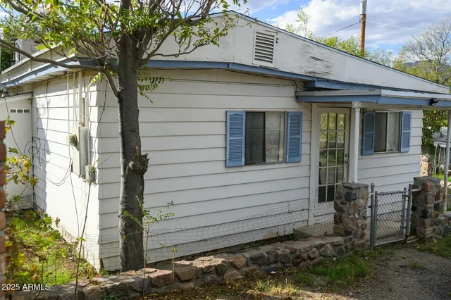 a view of a house with a window and wooden fence