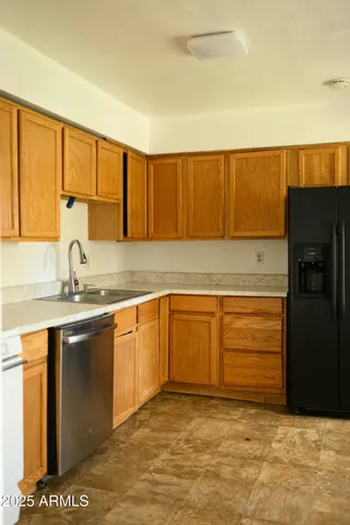 a kitchen with granite countertop a sink cabinets and stainless steel appliances