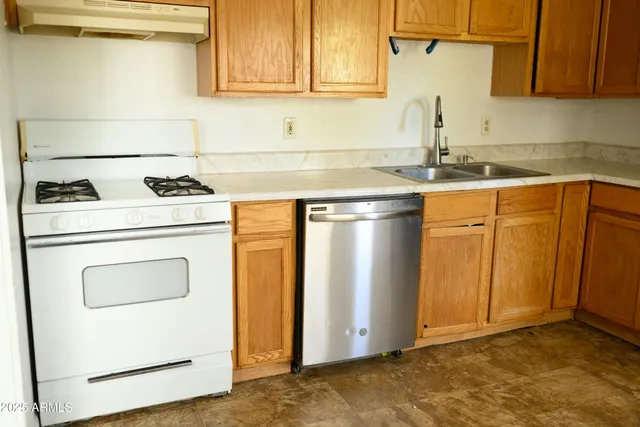 a kitchen with granite countertop cabinets stainless steel appliances and a counter space