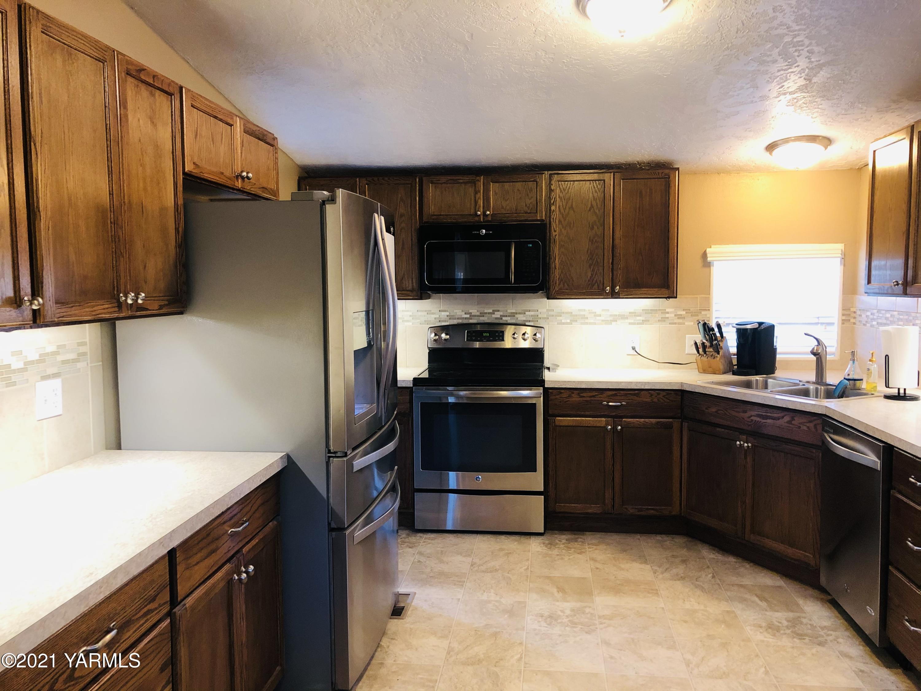13807 Knox Road Yakima, WA 98908 - Photo 23 of 30 a kitchen with a sink stove and refrigerator