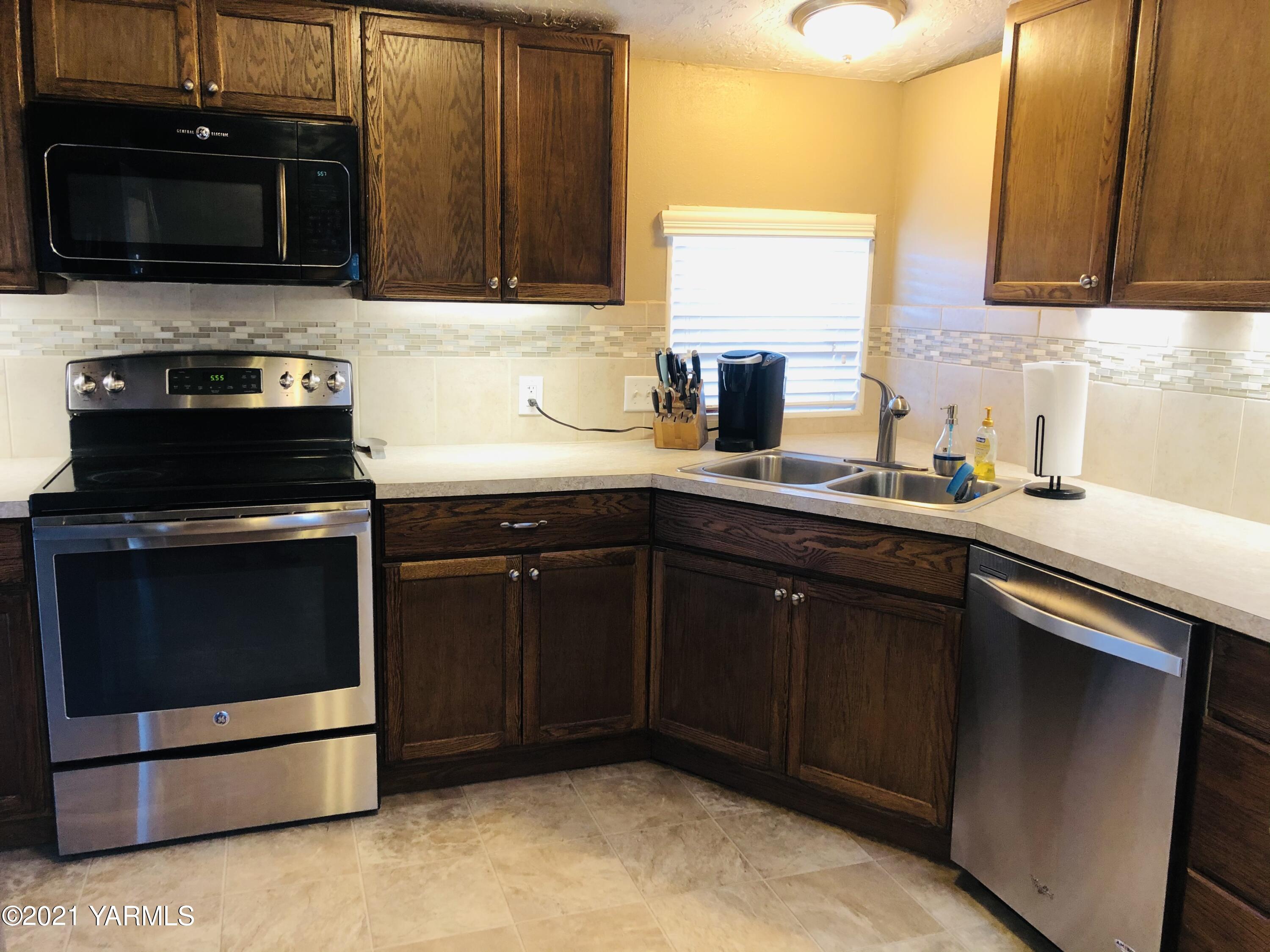 13807 Knox Road Yakima, WA 98908 - Photo 24 of 30 a kitchen with stainless steel appliances granite countertop a stove microwave and sink