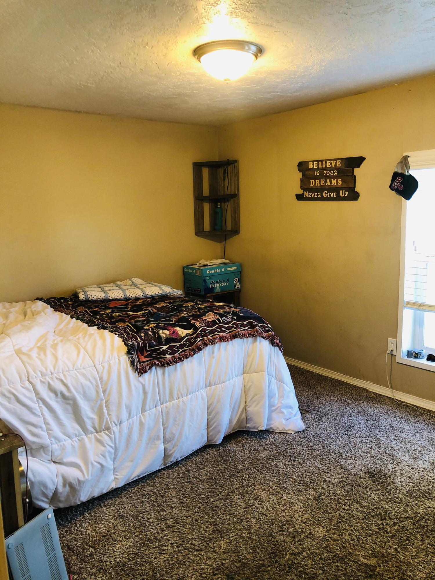 13807 Knox Road Yakima, WA 98908 - Photo 28 of 30 a bed sitting in a bedroom next to a blue wall