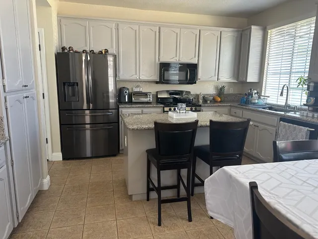a kitchen with a refrigerator and a stove top oven